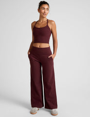 model is wearing red mid-rise wide leg pants with pockets.
