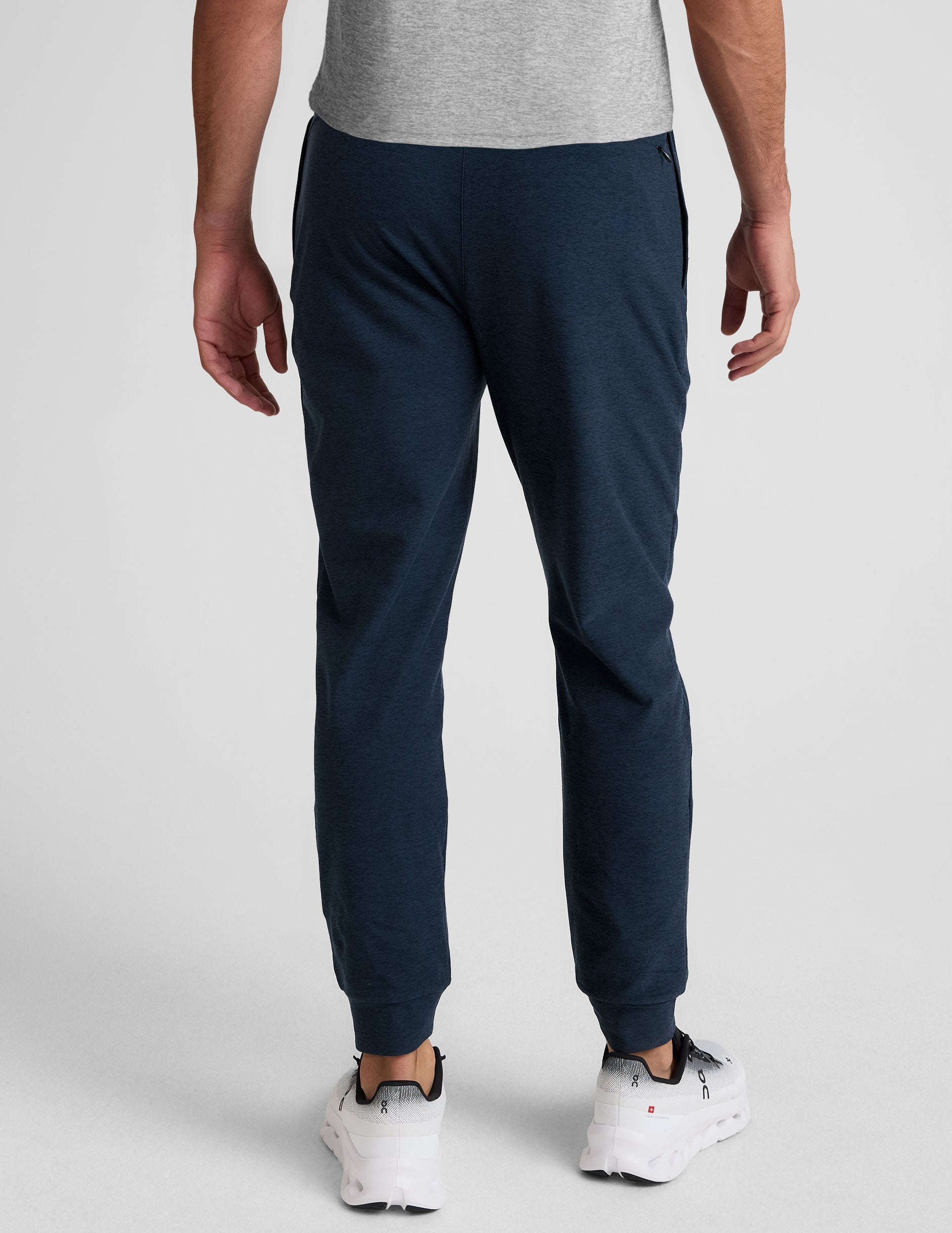 grey t-shirt and navy jogger pants on a plain background.