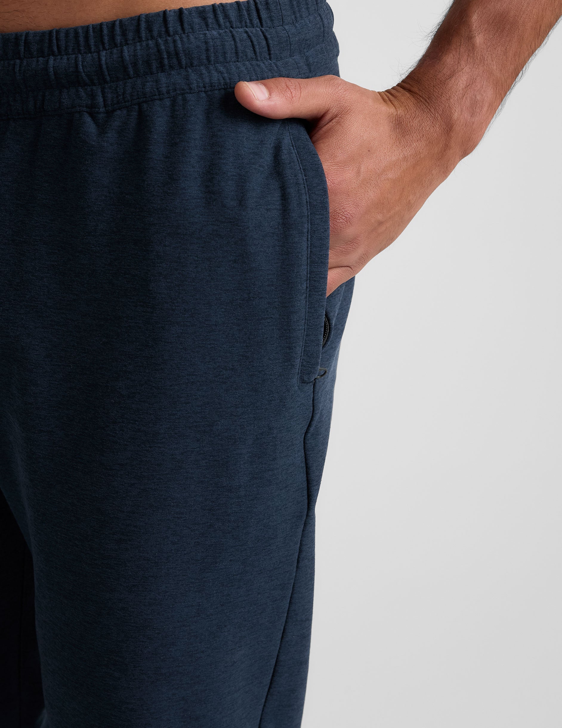 grey t-shirt and navy jogger pants on a plain background.