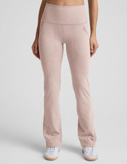 model wearing pink high-waisted bootcut pants with pockets set on a plain background.