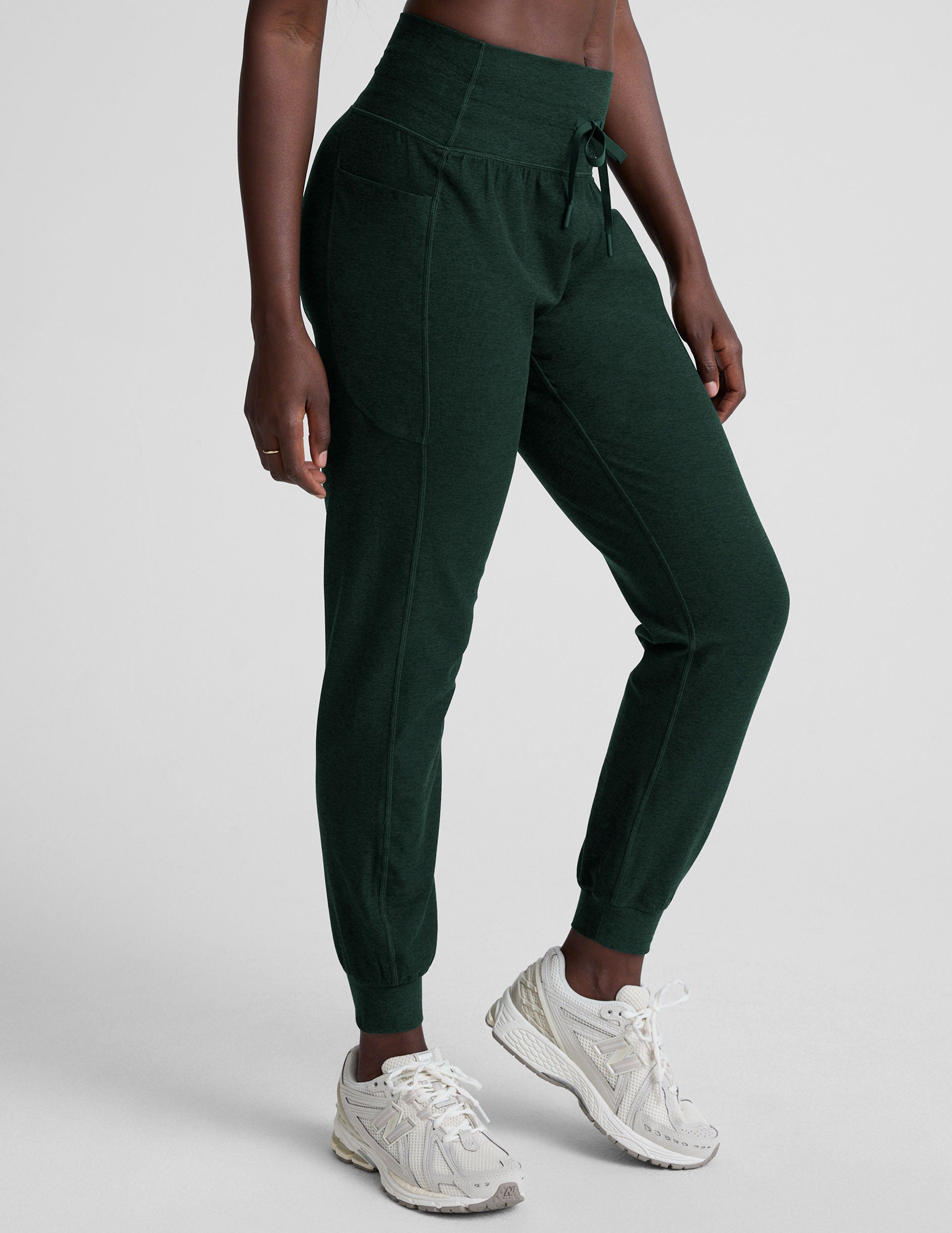 model wearing green midi length joggers with a drawcord at the waistband against a plain background.