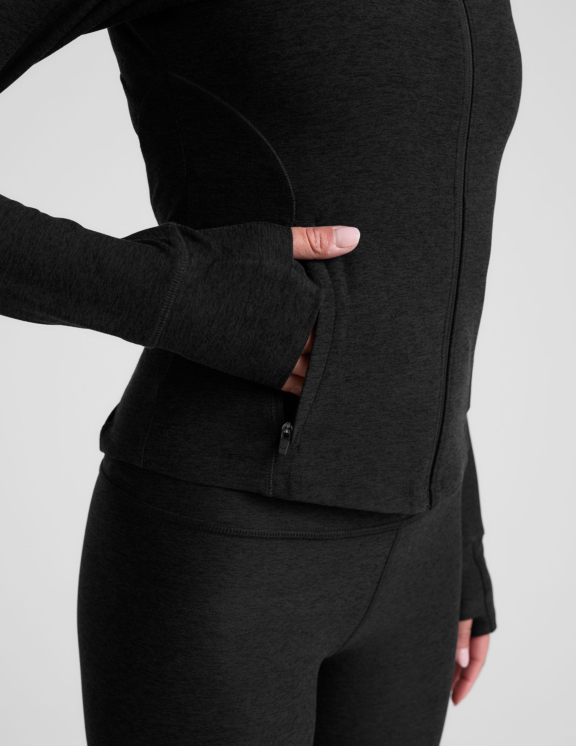 black zip-up mock neck jacket with pockets and thumbholes.