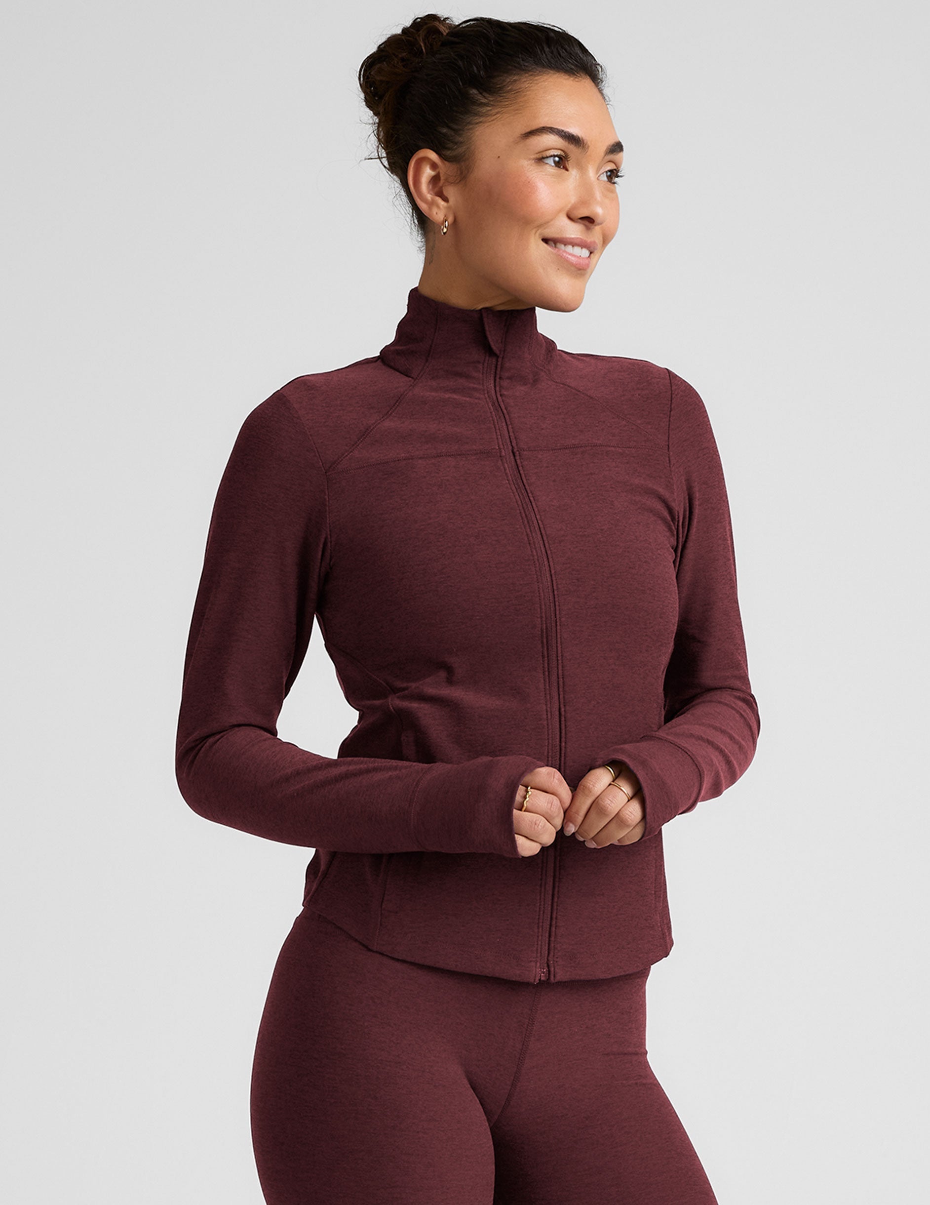 red zip-up mock neck jacket with pockets and thumbholes.