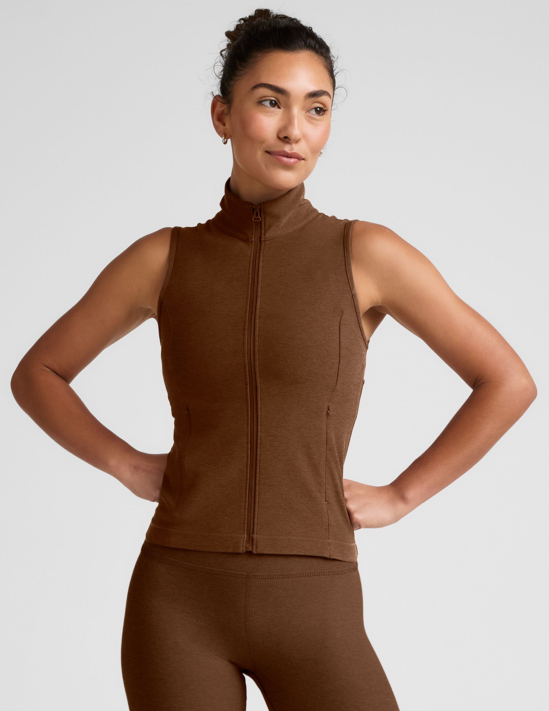 brown zip-up vest with a mesh upper back detail and pockets.