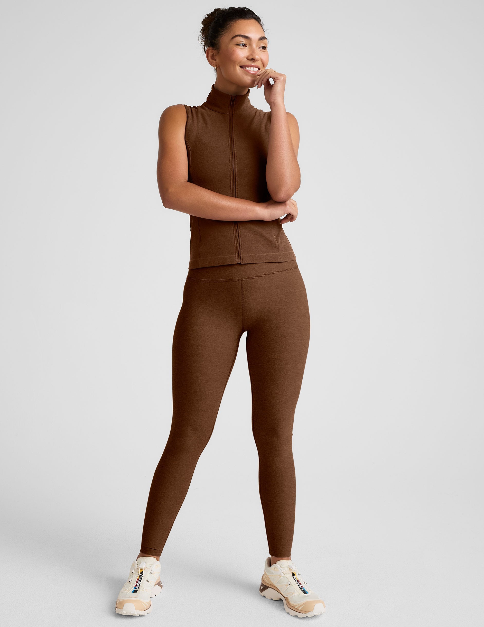 brown zip-up vest with a mesh upper back detail and pockets.