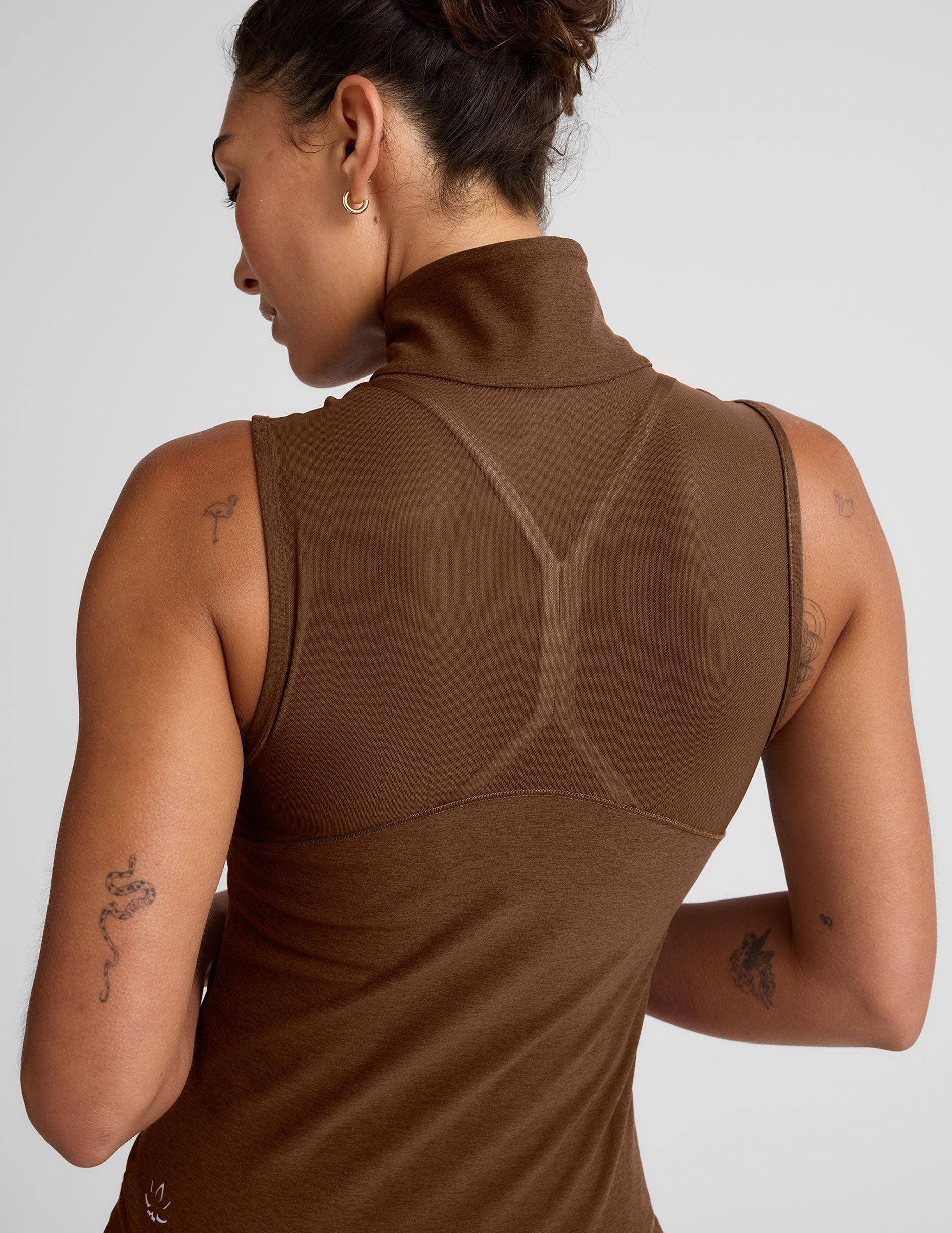 brown zip-up vest with a mesh upper back detail and pockets.