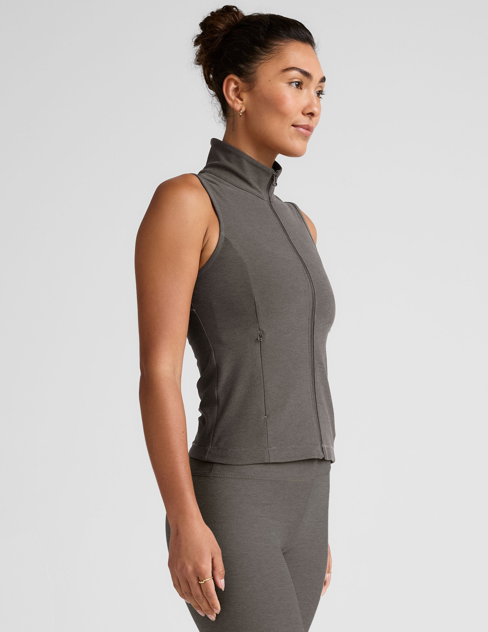 grey zip-up vest with mesh detail on upper back and pockets.