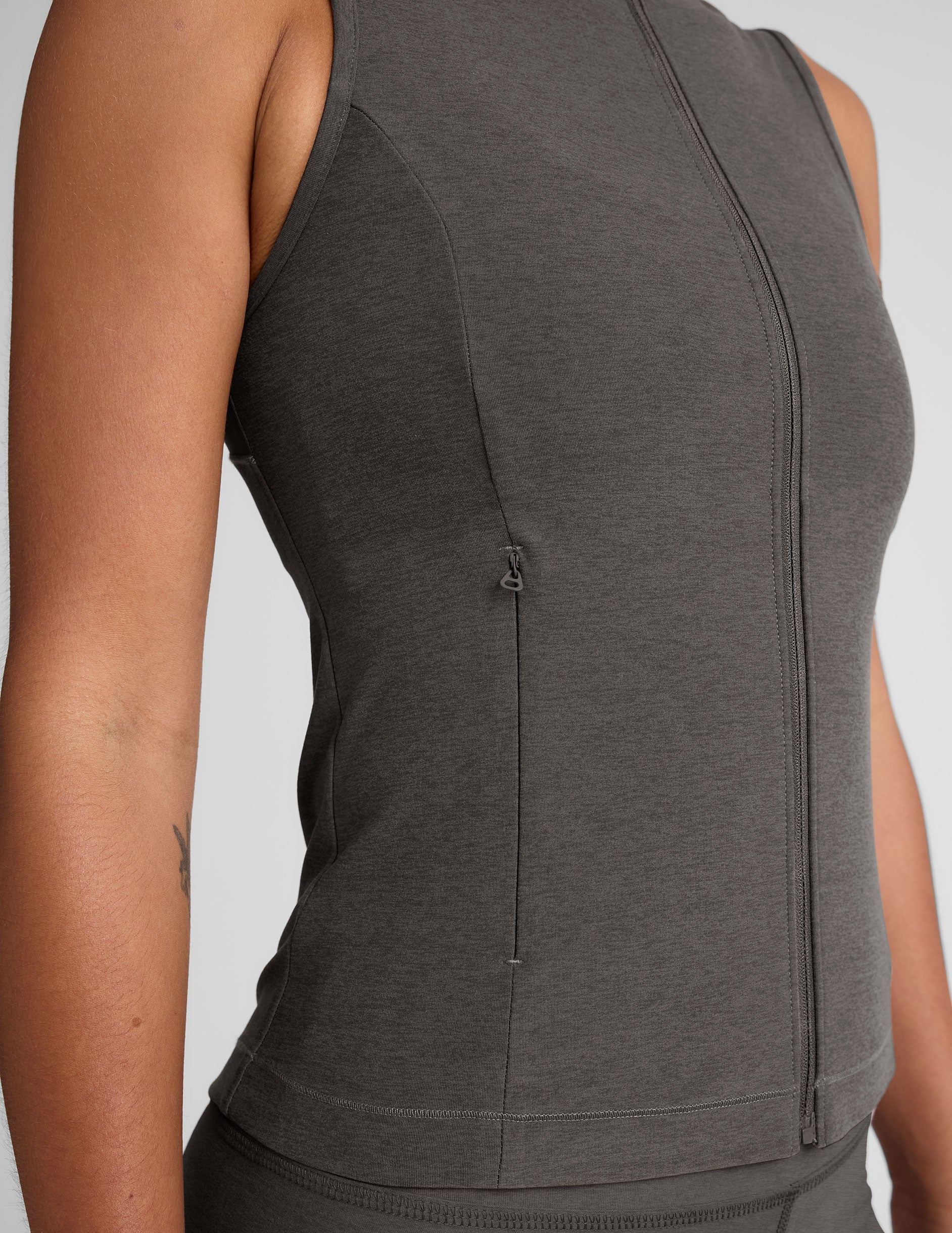 grey zip-up vest with mesh detail on upper back and pockets.
