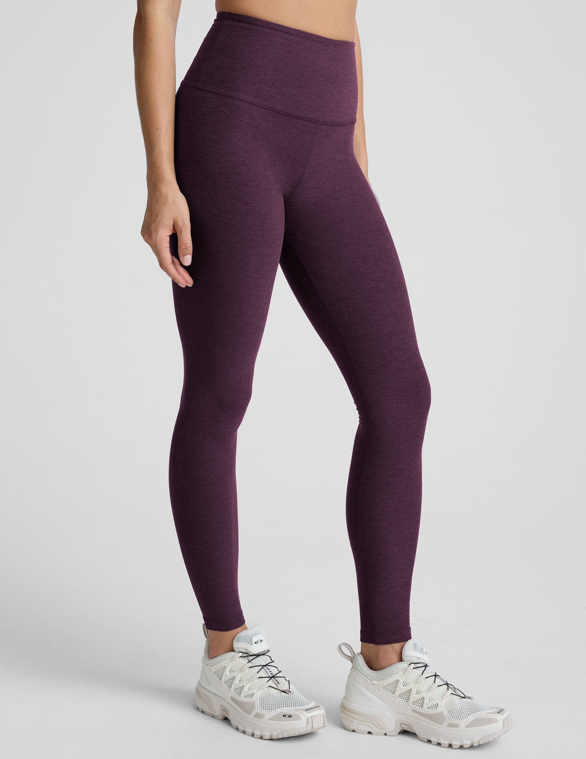model wearing purple high-waisted full length leggings on a plain background.