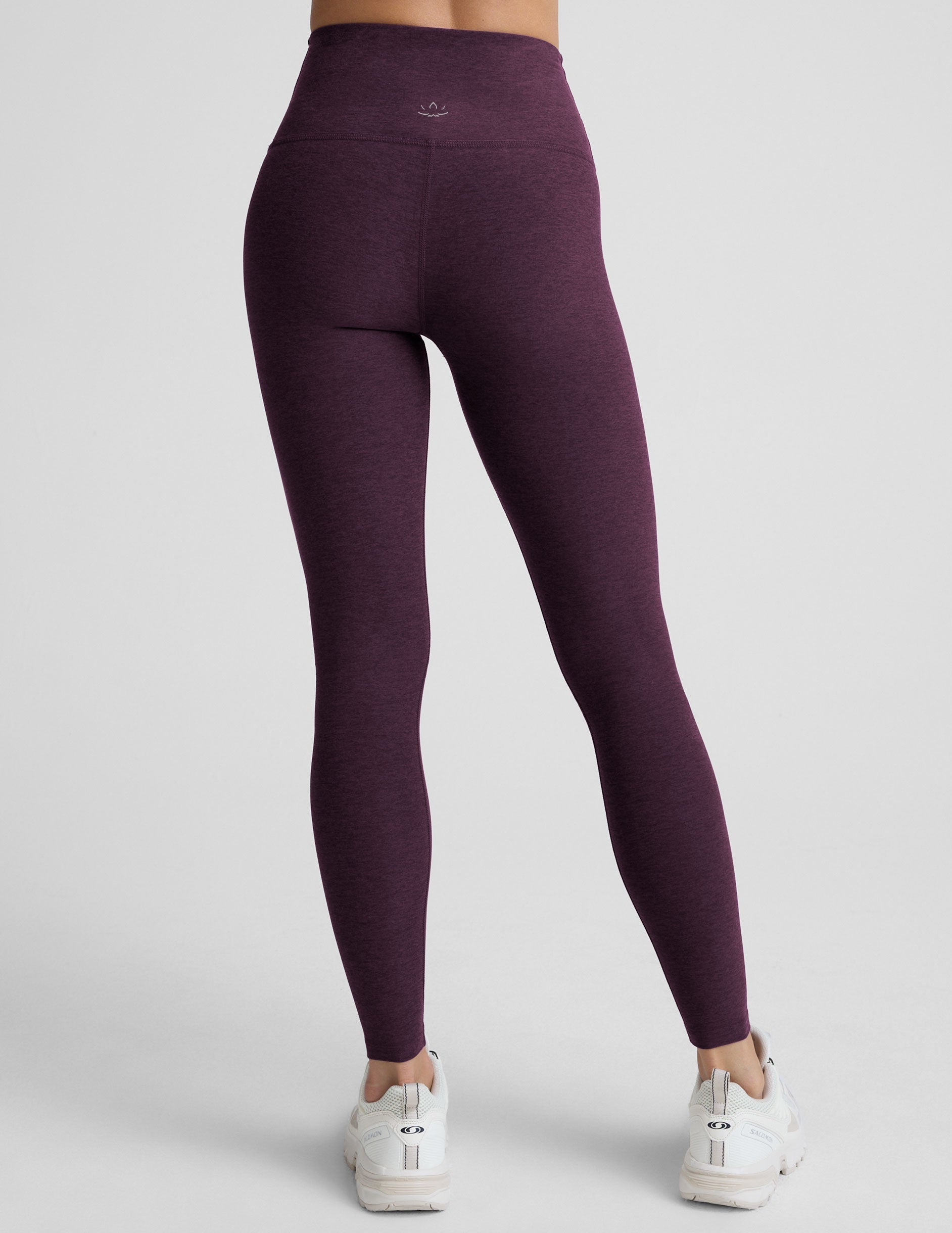 model wearing purple high-waisted full length leggings on a plain background.