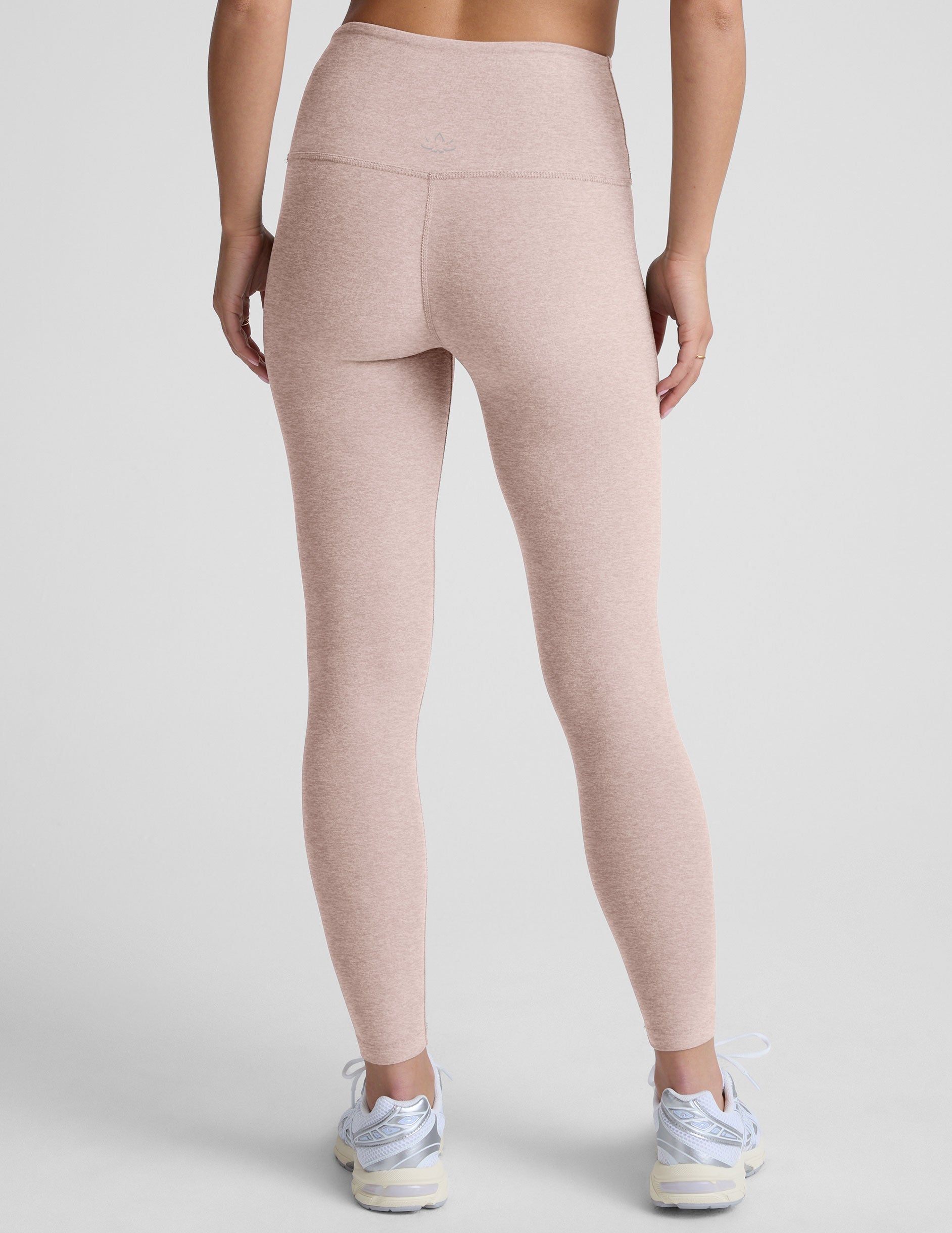 light pink high-waisted midi length leggings worn by model on a light gray background.