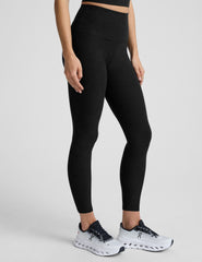 model wearing black high-waisted midi leggings on a white background.