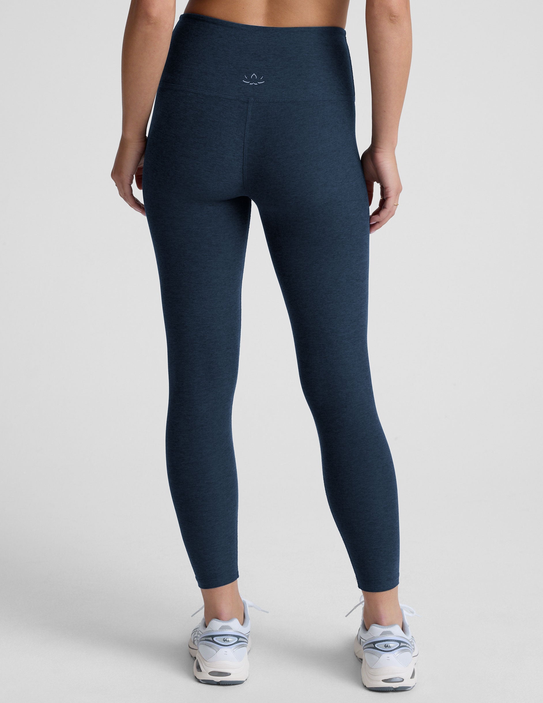 navy blue high-waisted midi leggings worn by model on a light gray background.