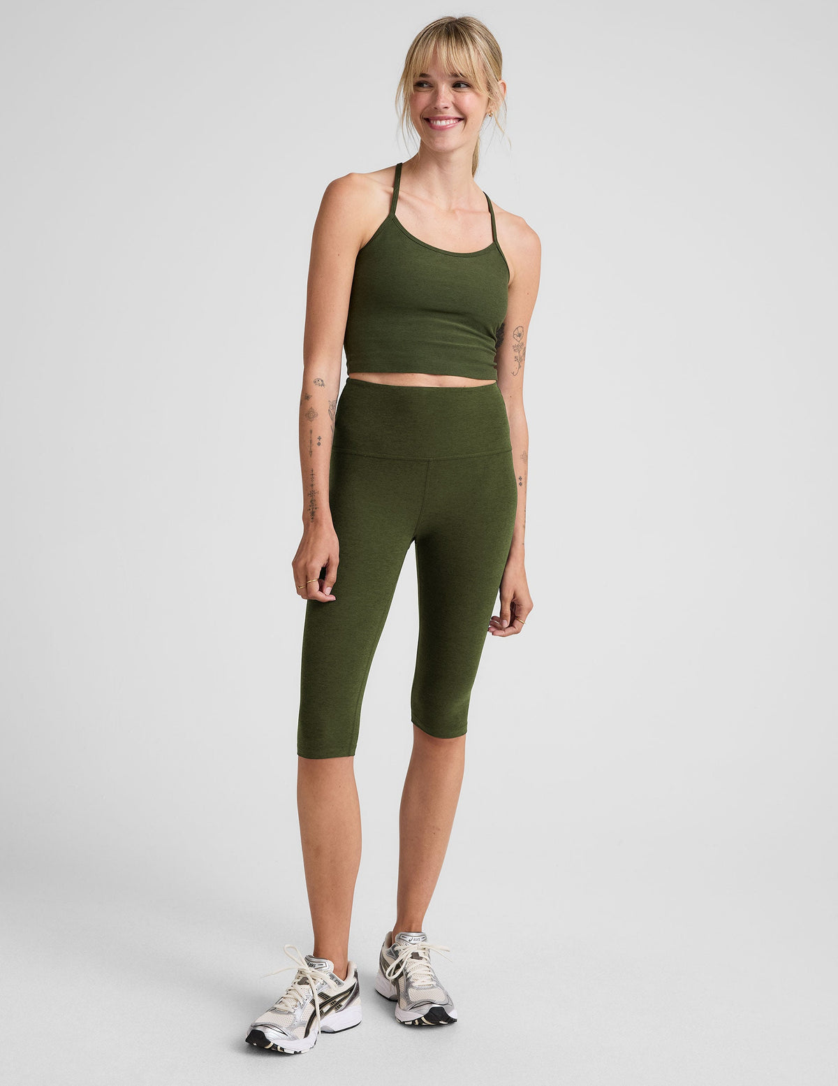 model is wearing green high-waisted pedal pusher length leggings.