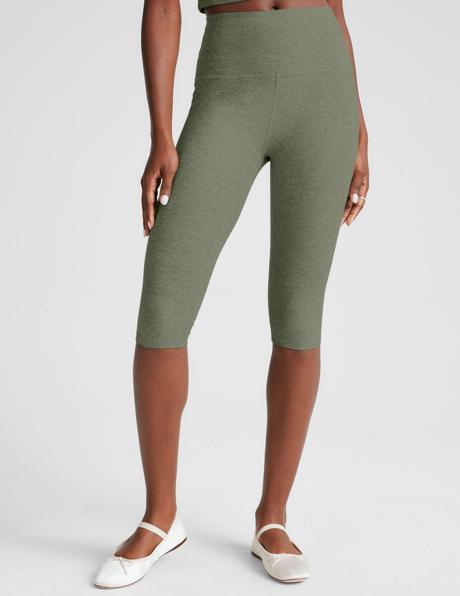 green high-waisted pedal pusher length leggings.