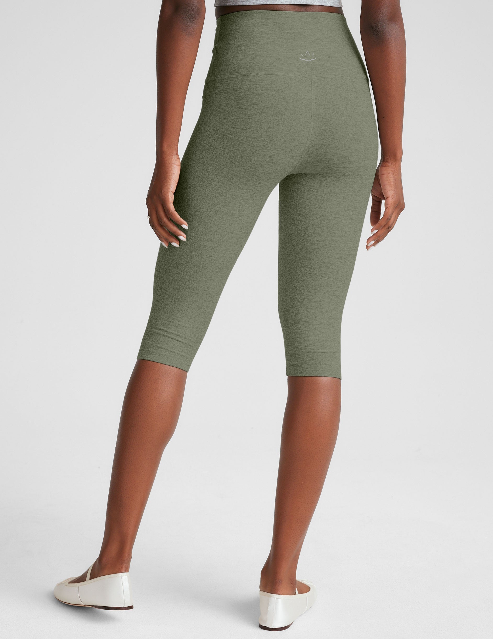 green high-waisted pedal pusher length leggings.