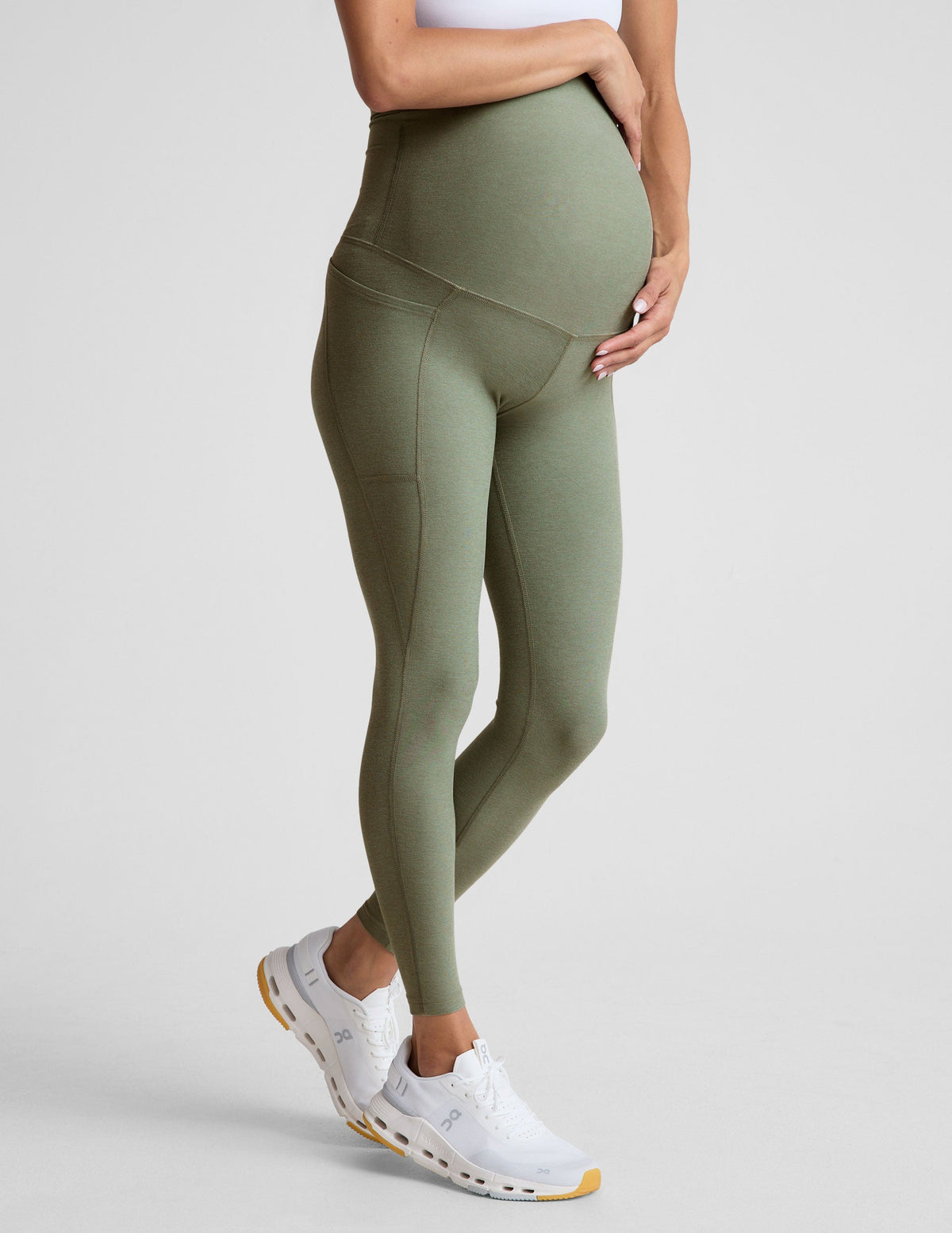 green high-waisted maternity leggings with pockets.
