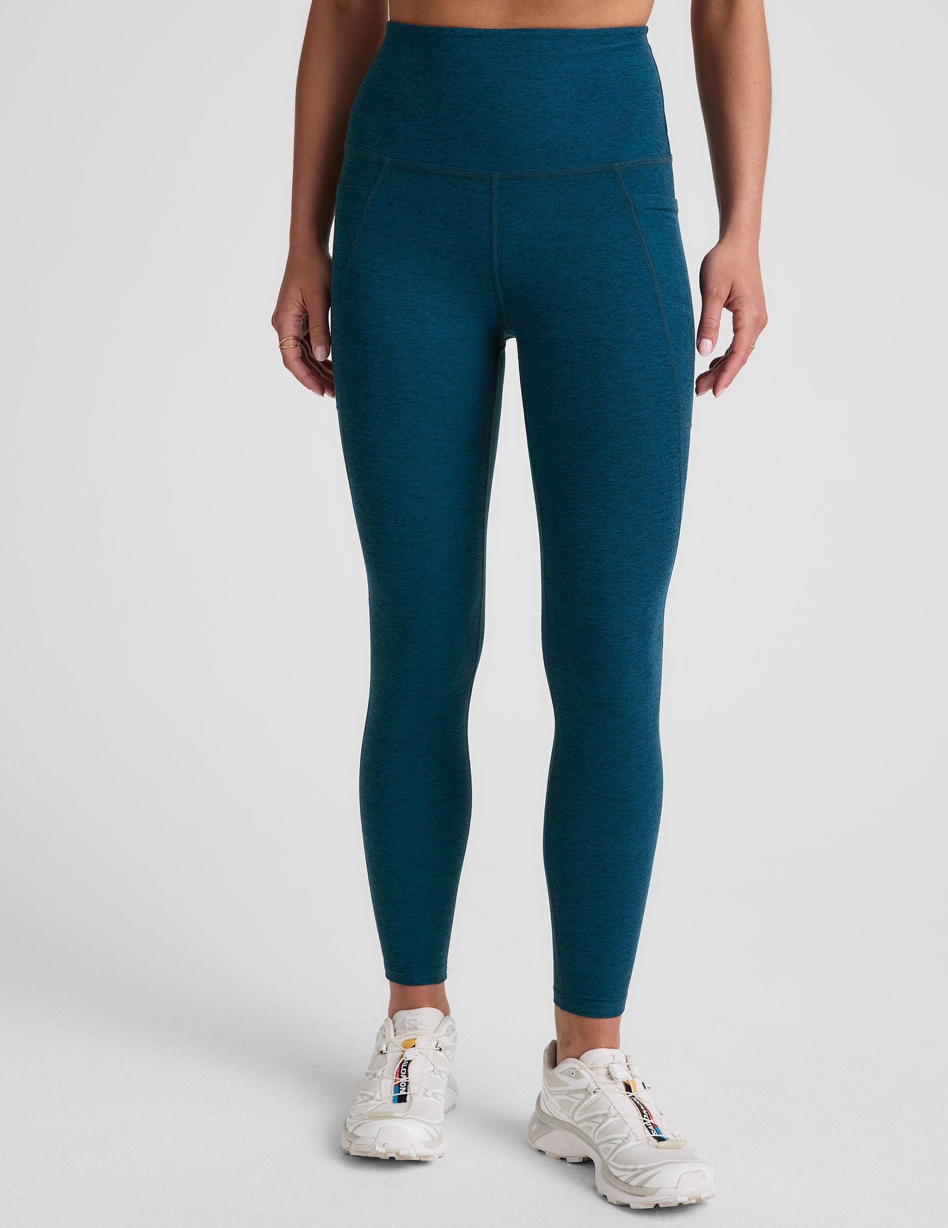 blue high-waisted midi length leggings with side pockets.