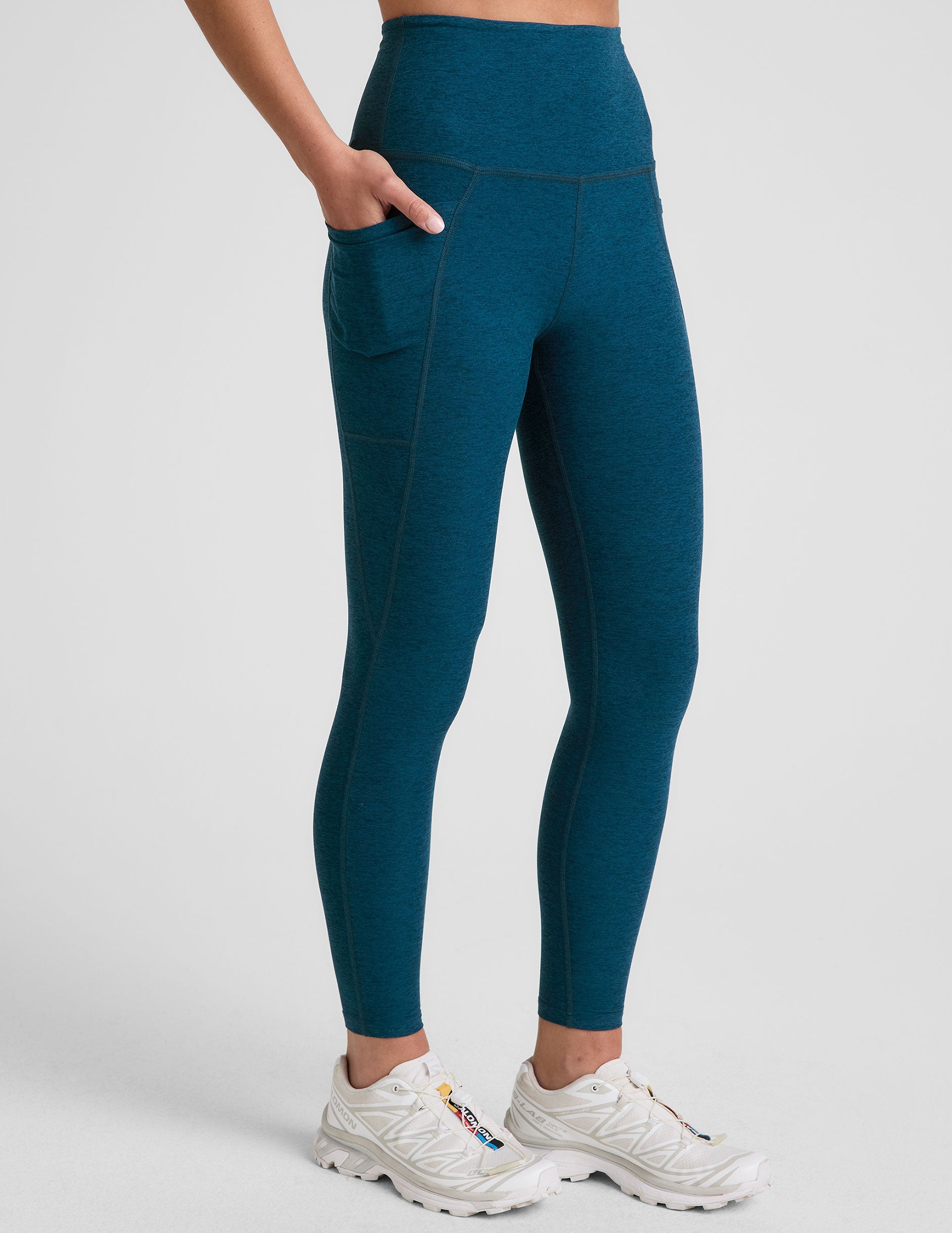 blue high-waisted midi length leggings with side pockets.