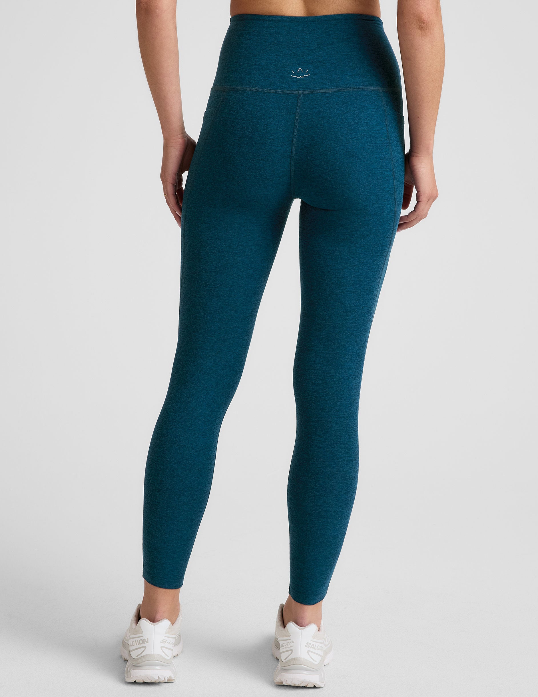 blue high-waisted midi length leggings with side pockets.