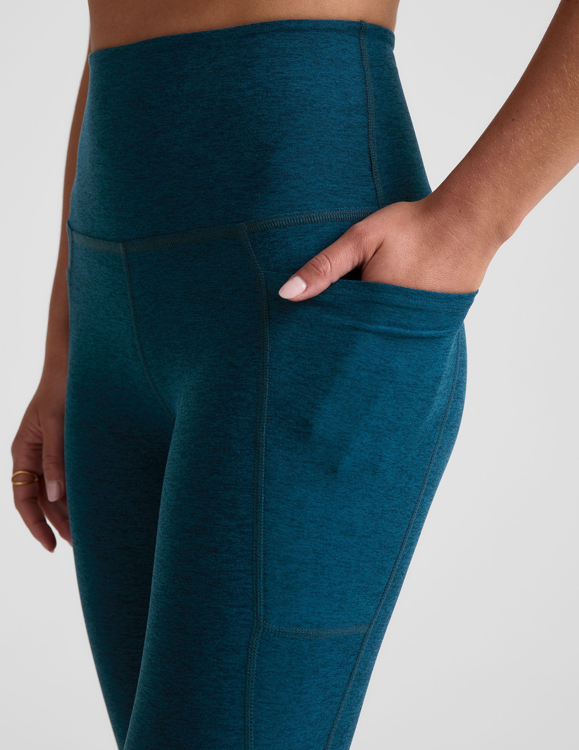 blue high-waisted midi length leggings with side pockets.