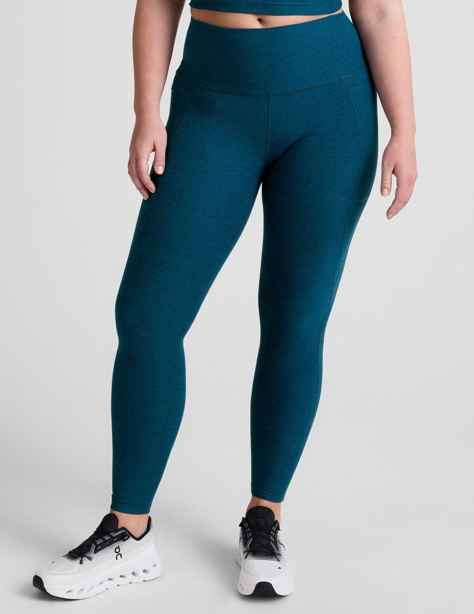 blue high-waisted midi length leggings with side pockets.