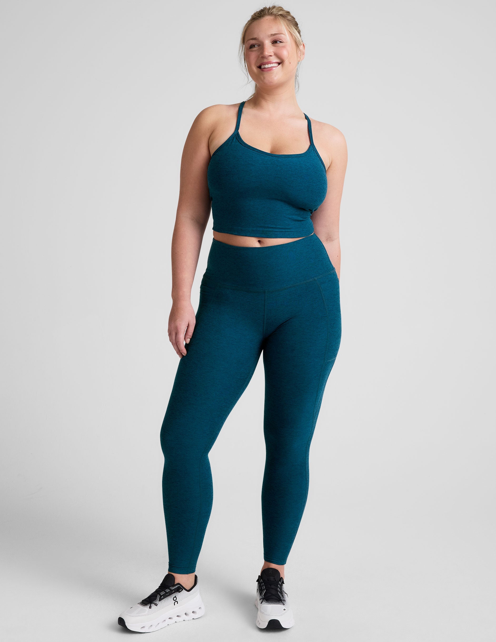 blue high-waisted midi length leggings with side pockets.