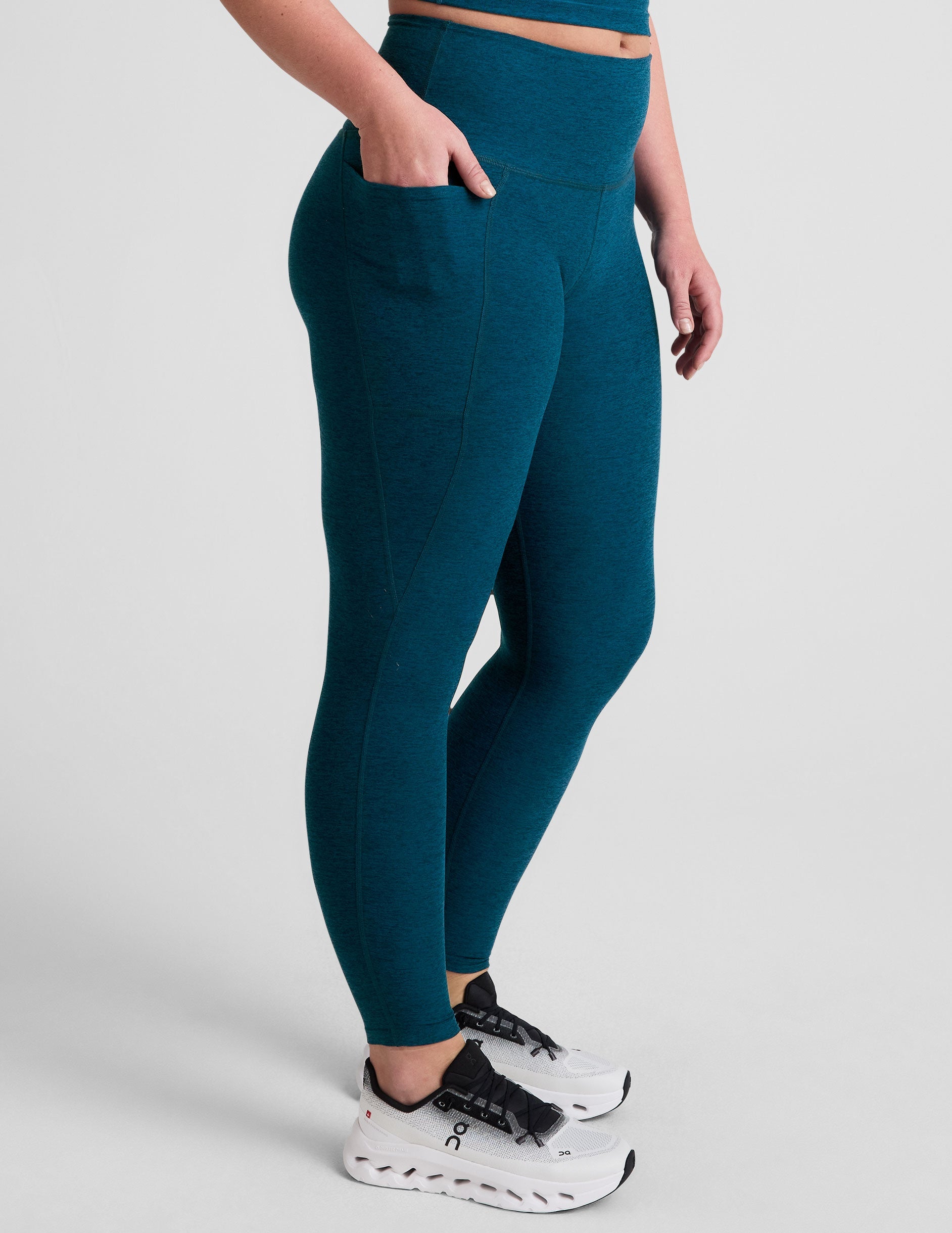 blue high-waisted midi length leggings with side pockets.