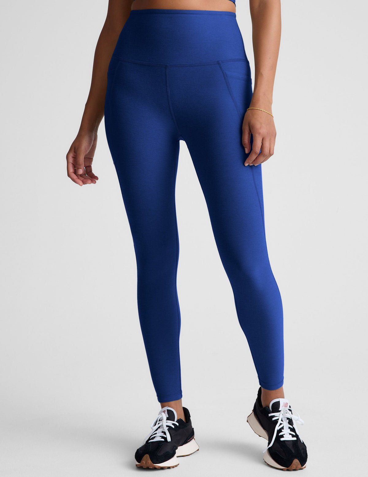 blue high-waisted midi length leggings with side pockets.