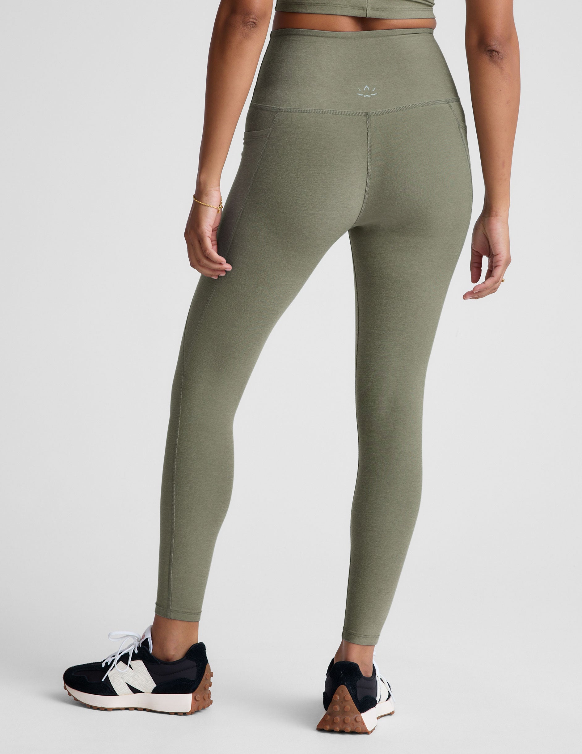 green high-waisted midi length legging with side pockets.