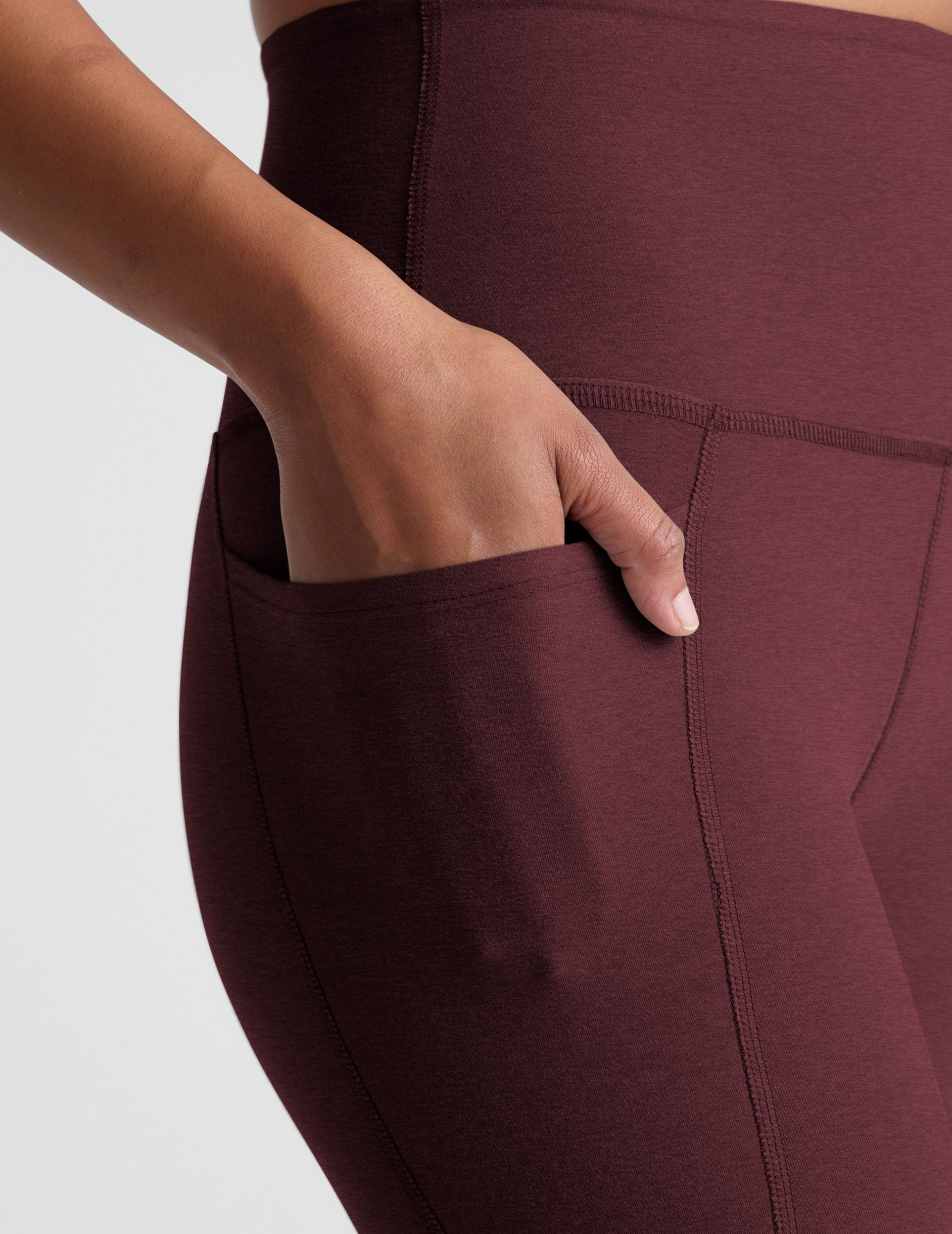 red high-waisted midi length leggings with pockets.