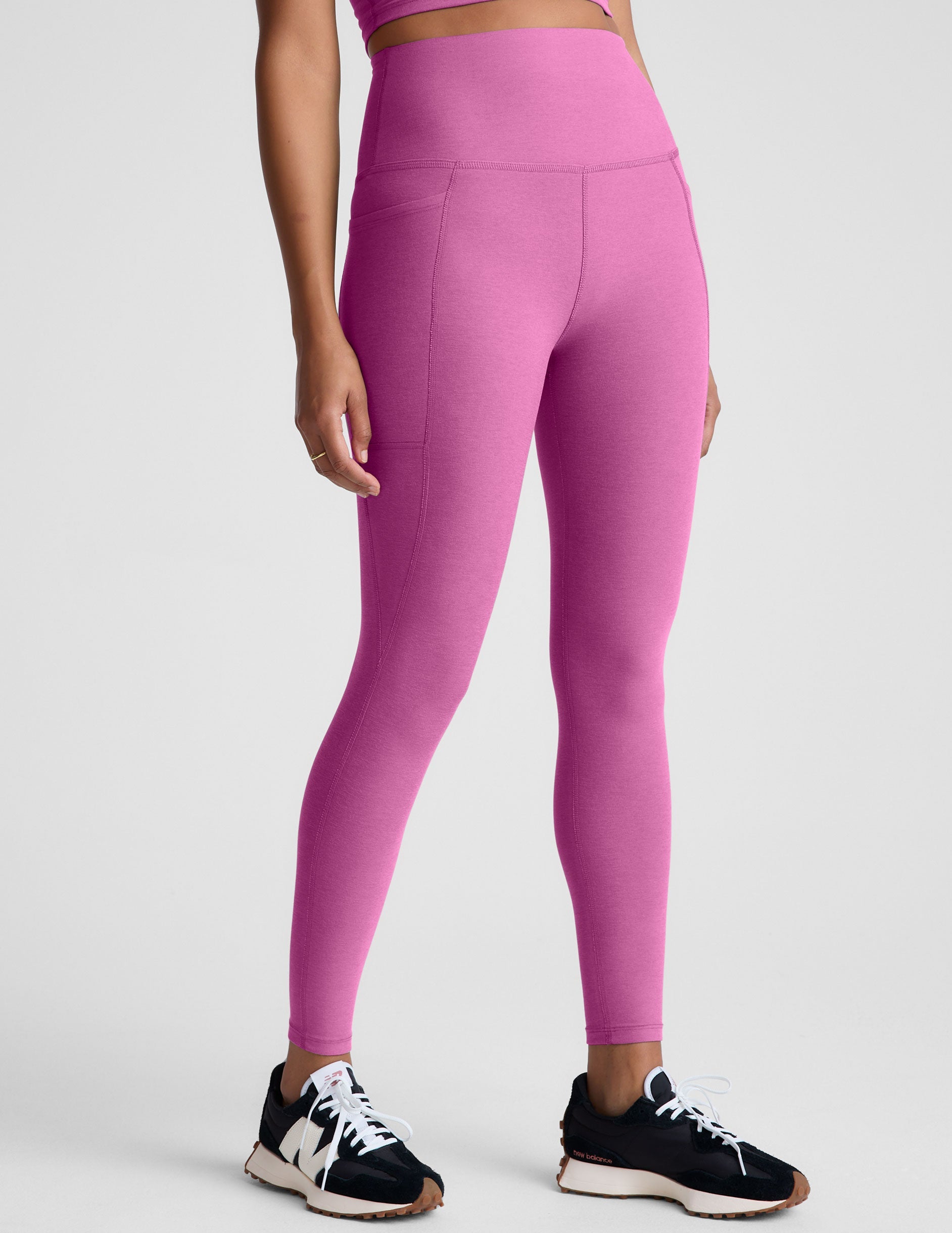 pink high-waisted midi length leggings with side pockets.