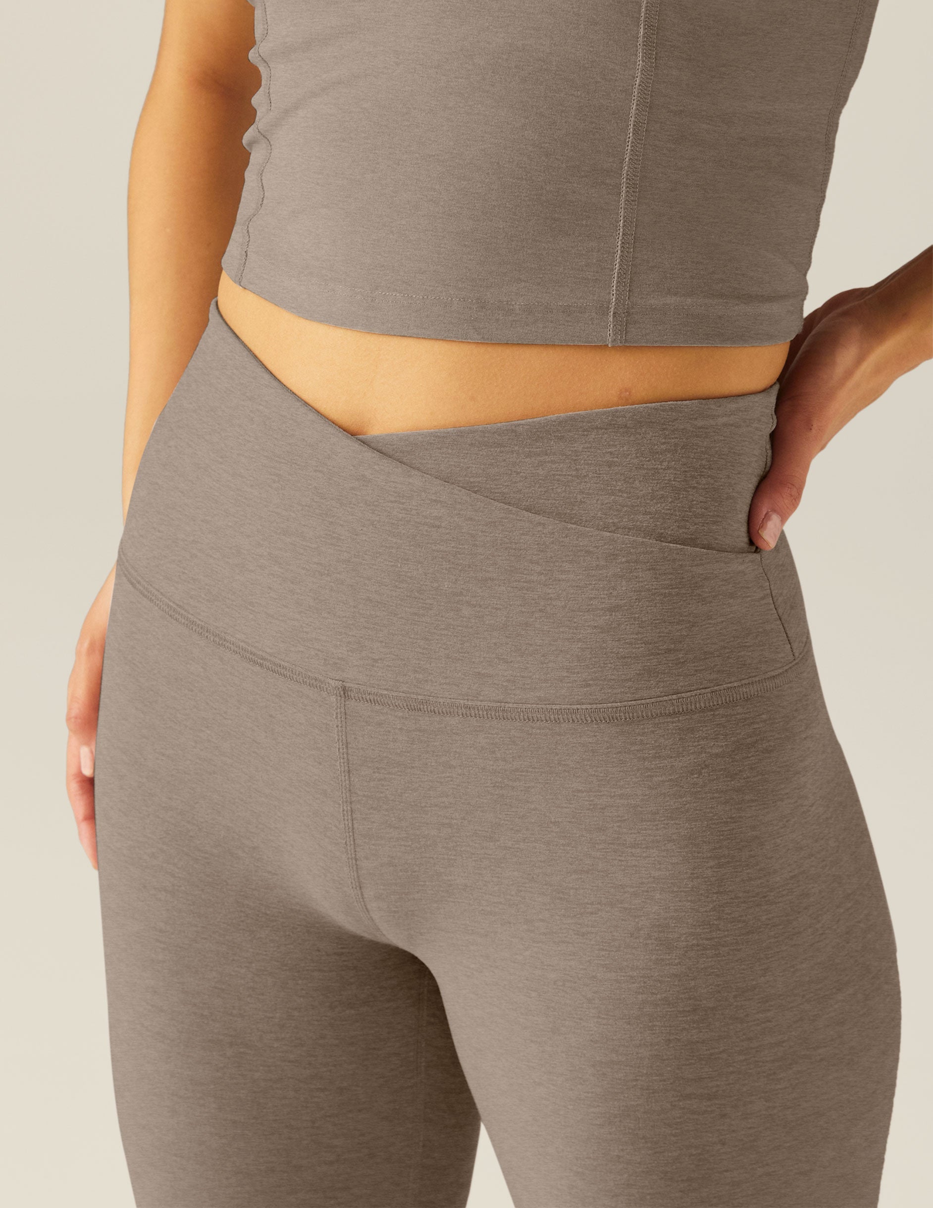 brown high-waisted midi leggings with a front crossover waistband.
