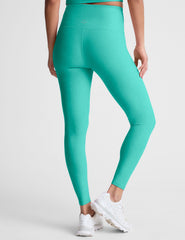 blue high-waisted midi length leggings with a crossover detail on the front waistband.