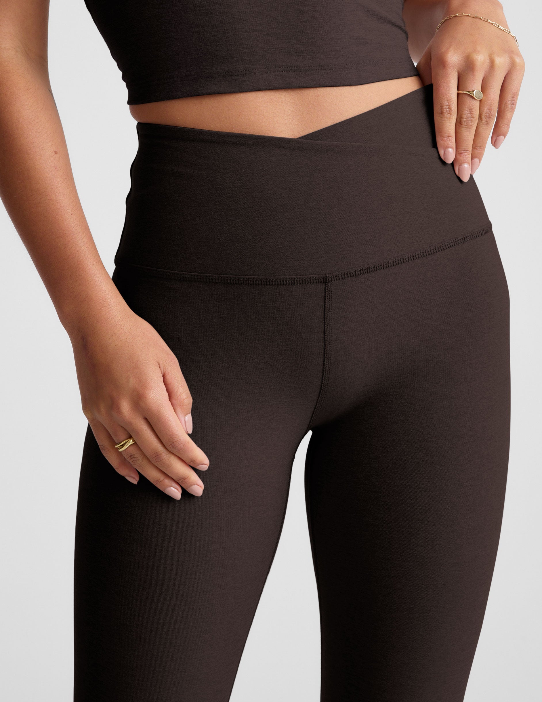 brown high-waisted midi length leggings with an overlapping front waistband.