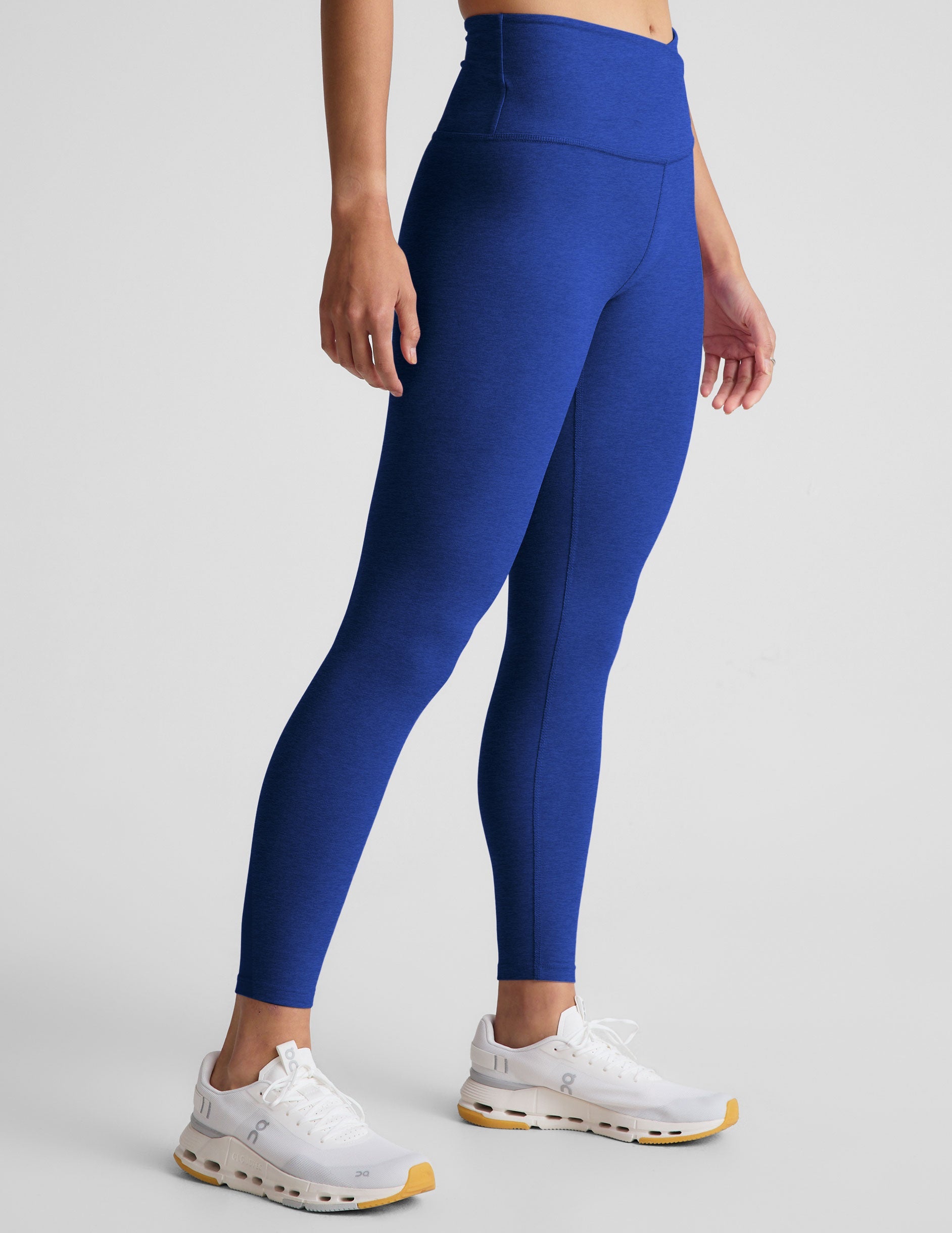 blue high-waisted midi leggings with a crossover detail on the front waistband.