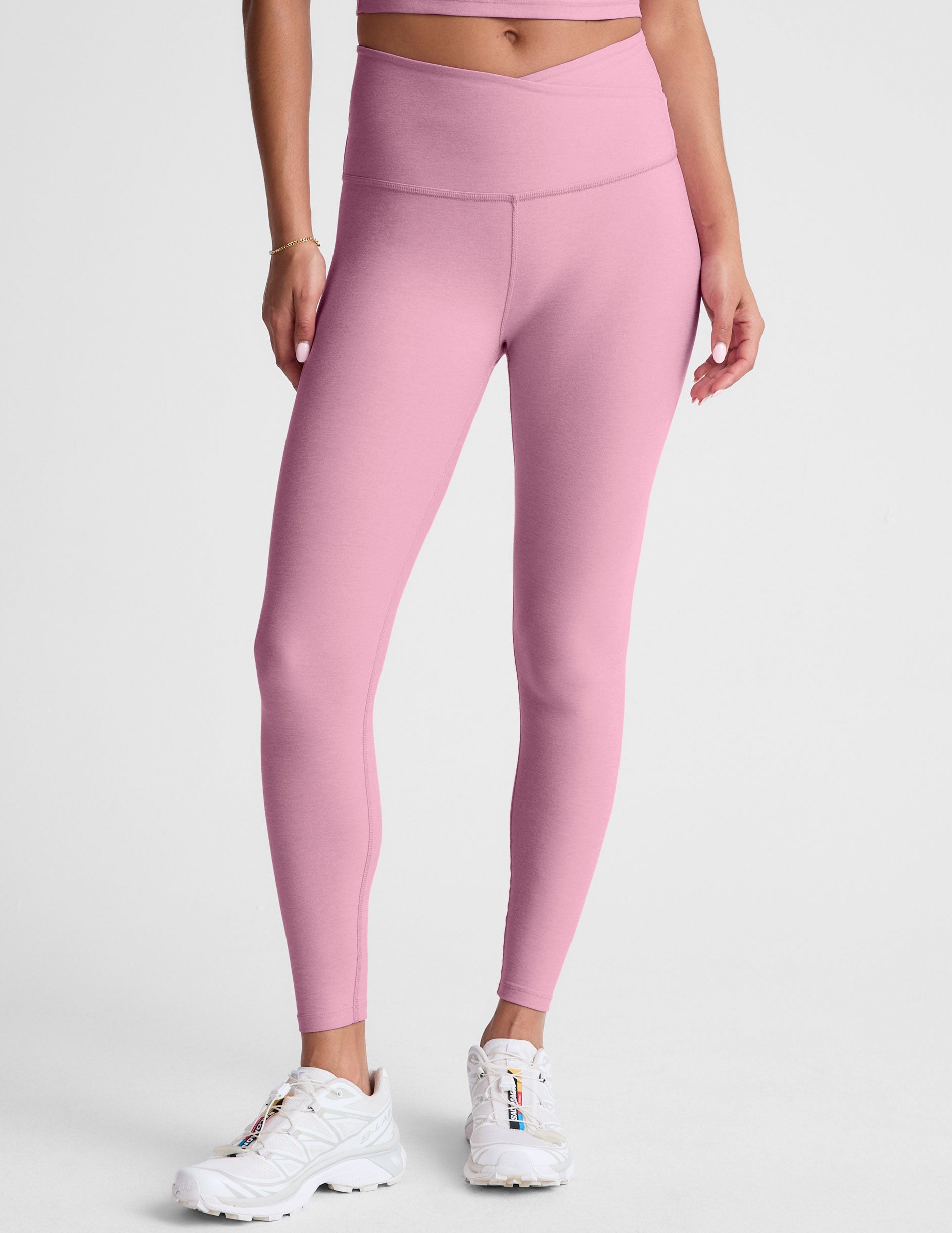 pink high-waisted midi leggings with a crossover detail on the front waistband.