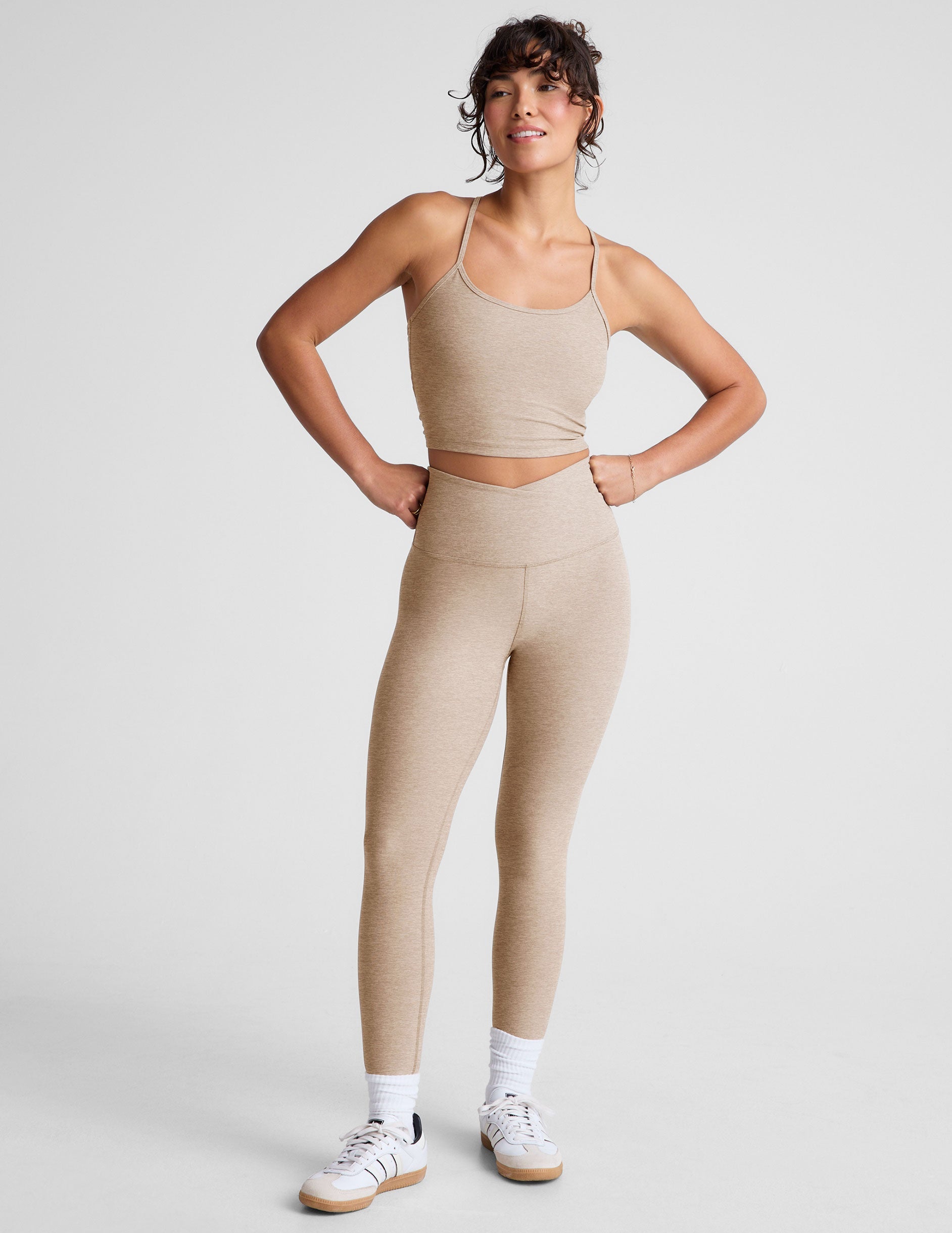 brown high-waisted midi length leggings with a crossover detail on the front waistband.