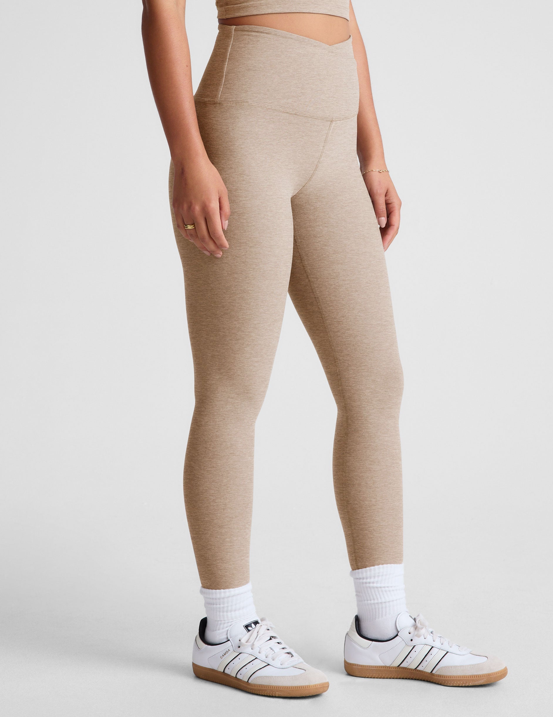 brown high-waisted midi length leggings with a crossover detail on the front waistband.