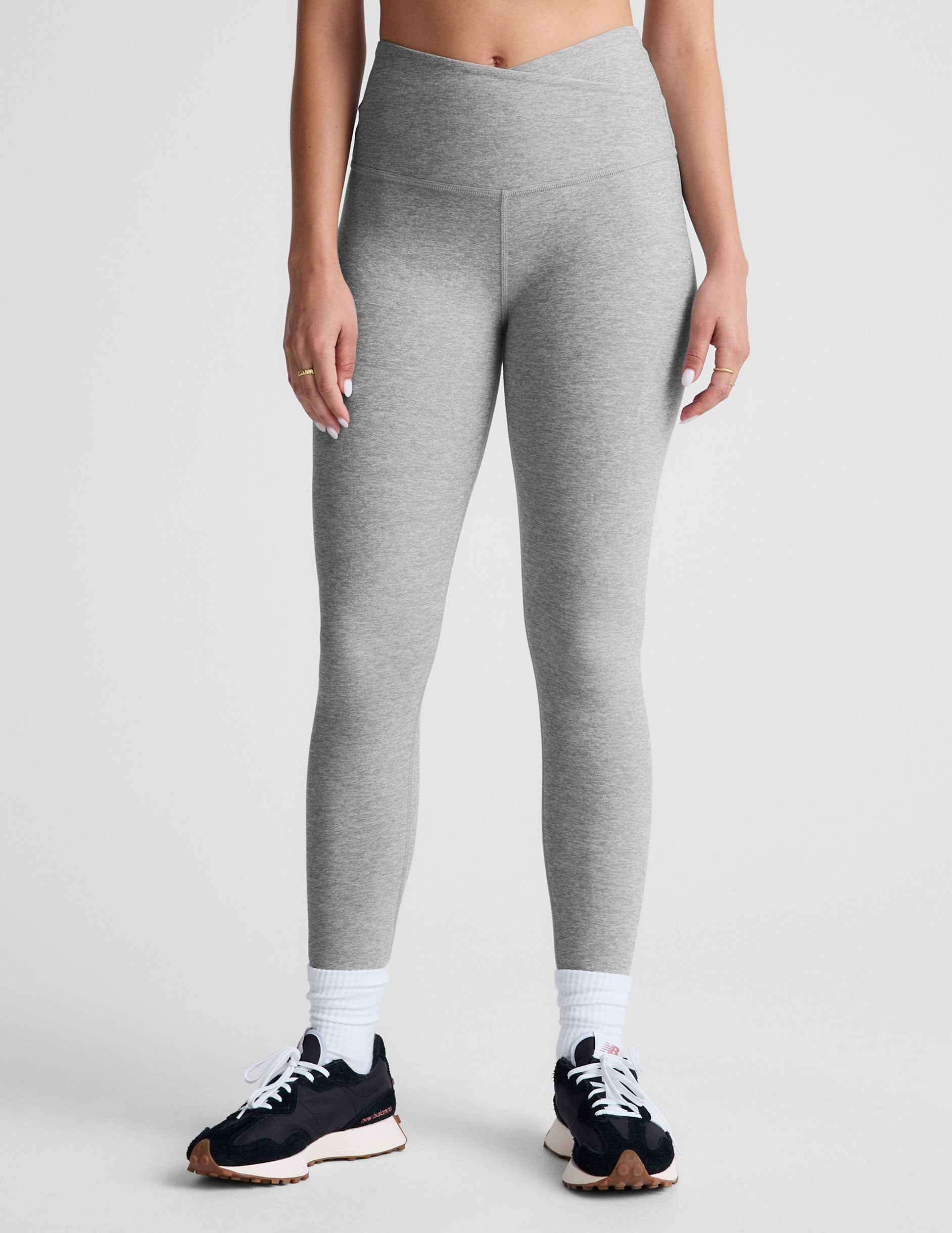 gray high-waisted midi length leggings with a crossover detail on the front waistband.
