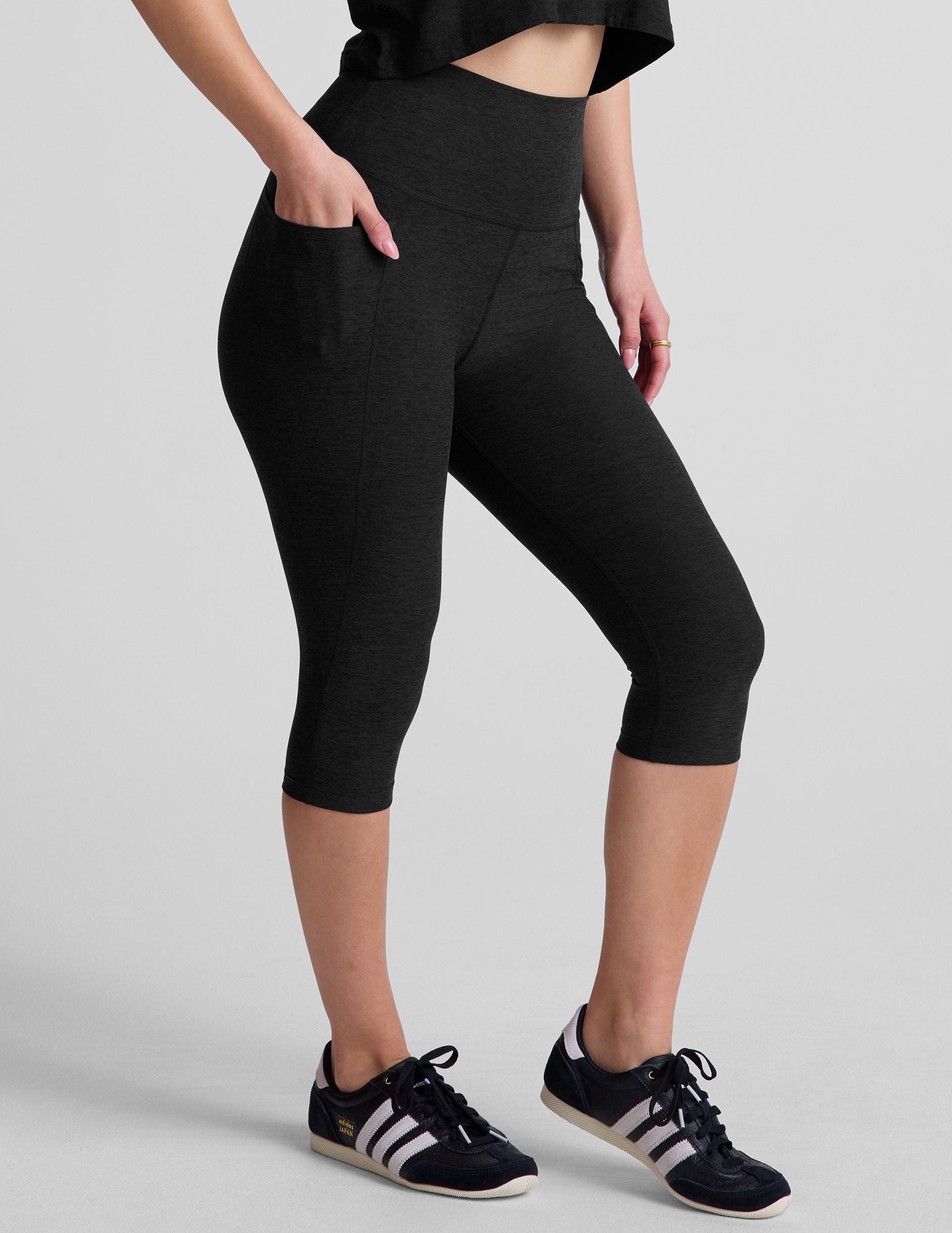 black high-waisted pedal pusher length leggings with pockets.