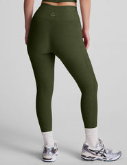 model is wearing green high-waisted capri length leggings with pockets.