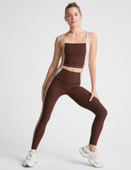 brown high-waisted midi leggings with white lining on the sides.