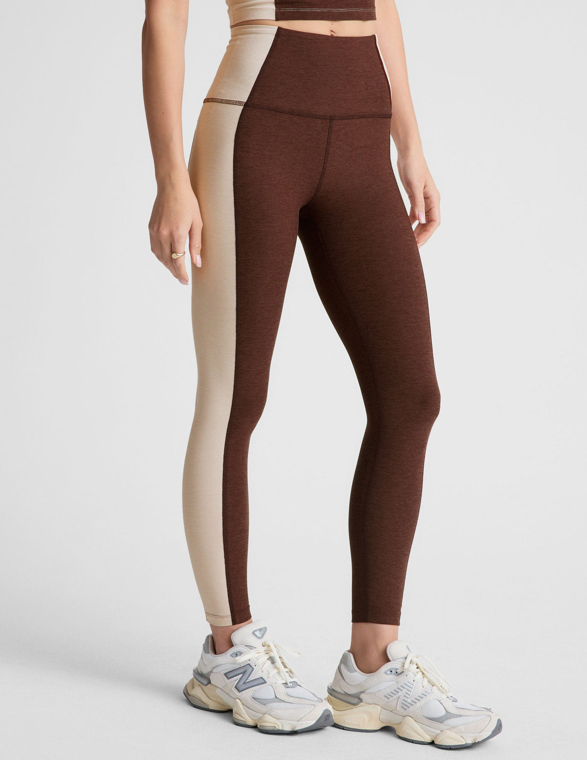 brown high-waisted midi leggings with white lining on the sides.