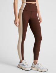 brown high-waisted midi leggings with white lining on the sides.