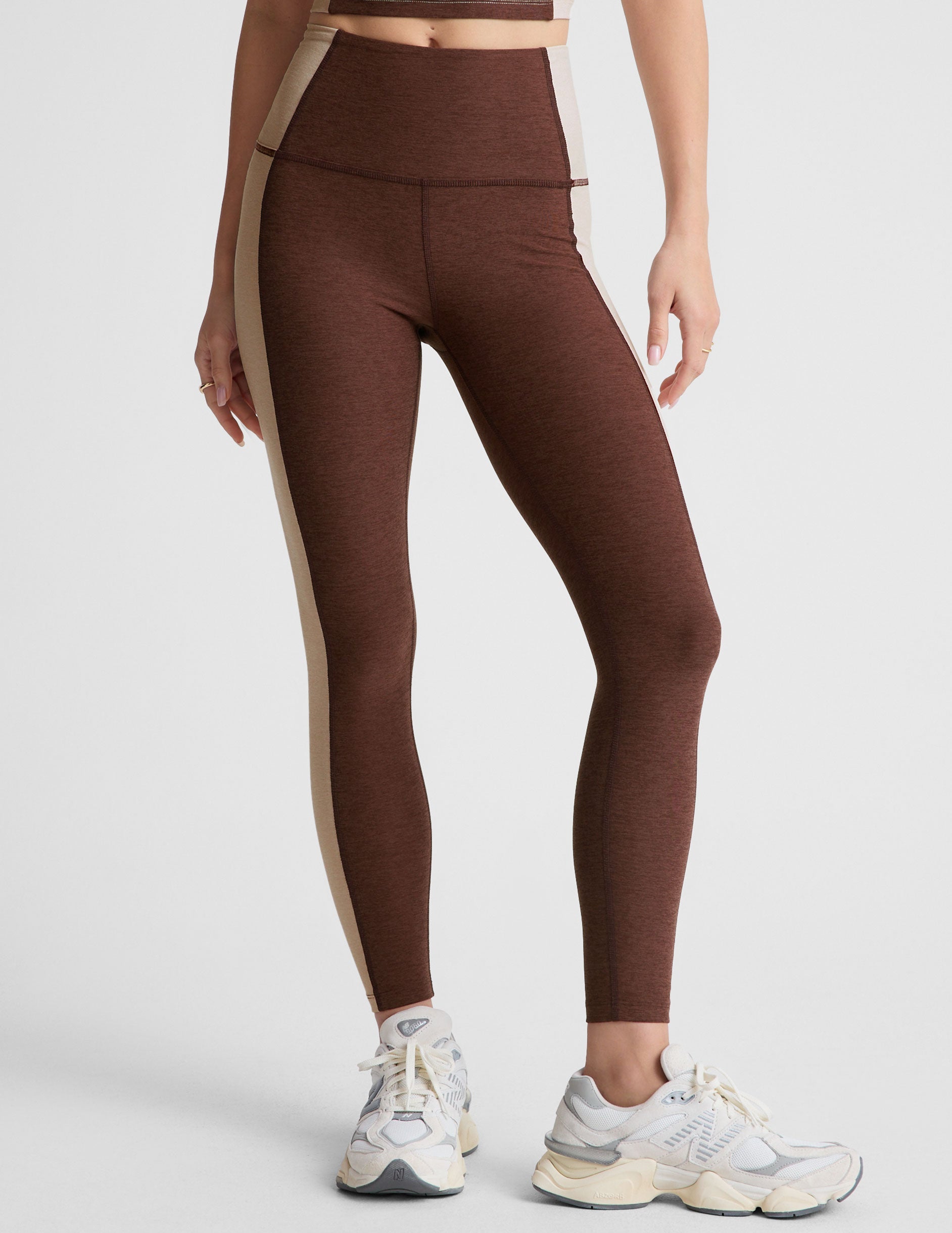 brown high-waisted midi leggings with white lining on the sides.