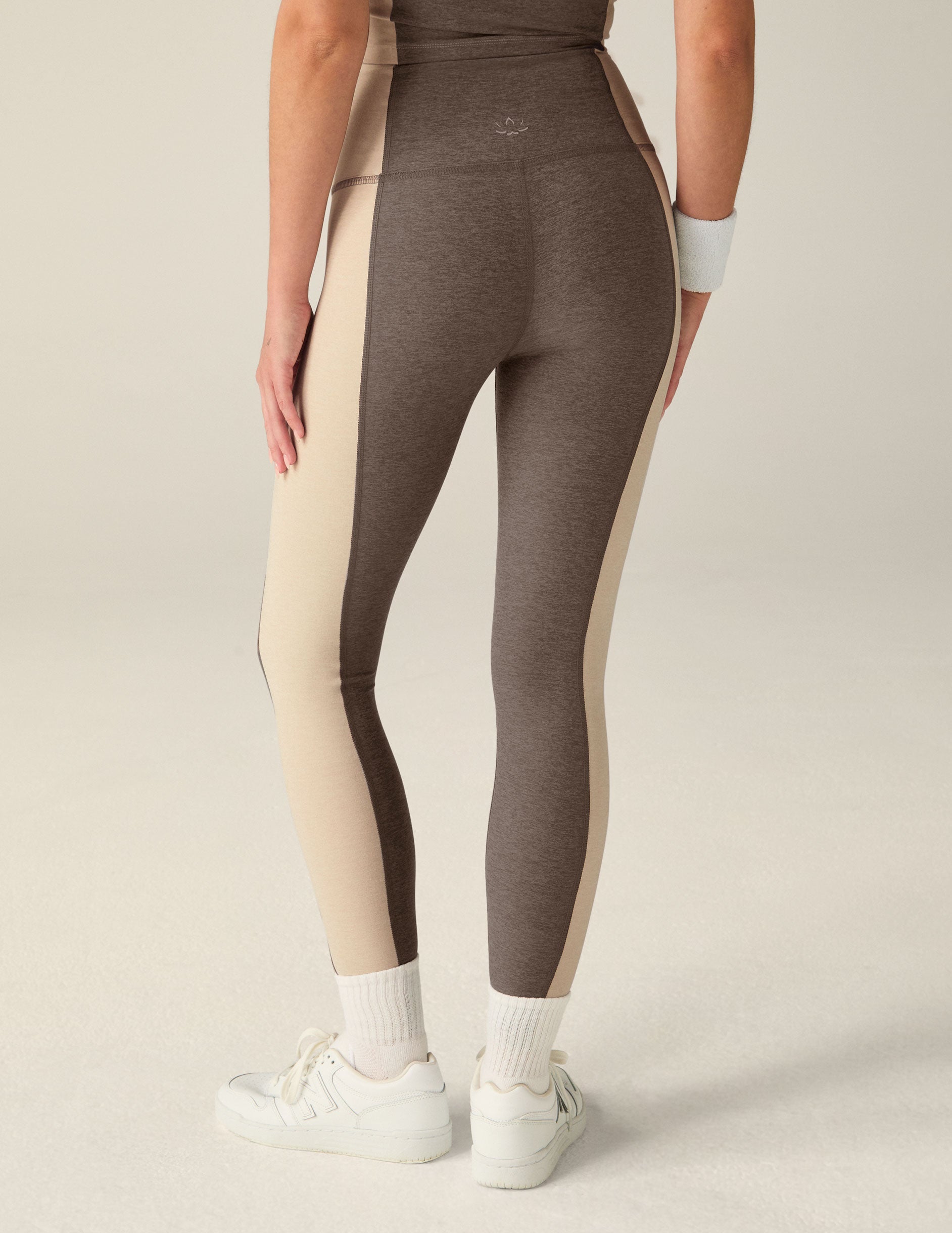 brown high-waisted midi leggings with eggshell outline details on the sides.
