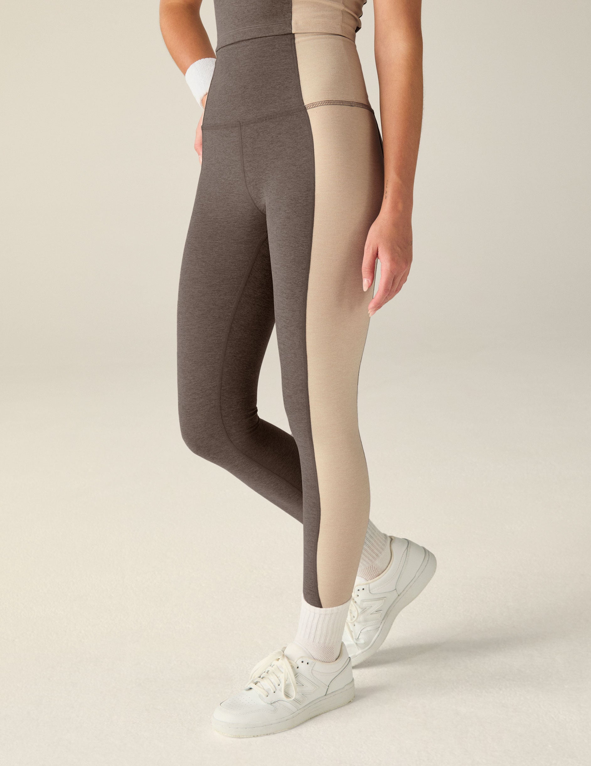 brown high-waisted midi leggings with eggshell outline details on the sides.