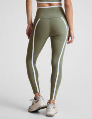 green high-waisted midi length legging with side pockets and white piping.