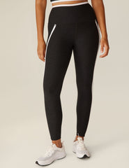black pocket high-waisted midi legging with white lining around waistband and down the sides.